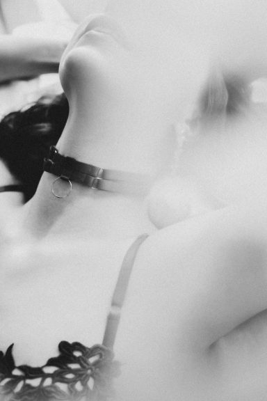 Intime Schwarz-Weiß-Nahaufnahme einer Frau mit schwarzem Halsband und detailreicher Lingerie.